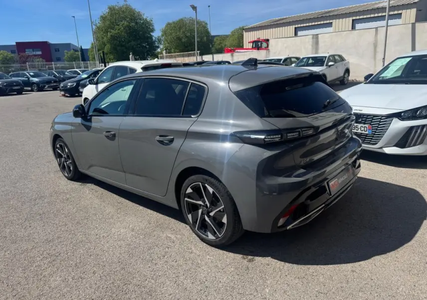 Peugeot 308 Hybrid gris vue 3/4 arrière droit, avec jantes alliage 17 pouces et vitres teintées.