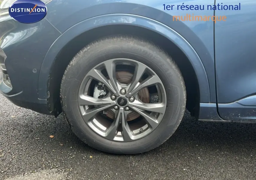 Gros plan sur la roue avant gauche du Ford Kuga bleu chrome métal, mettant en valeur la jante alliage 18 pouces.
