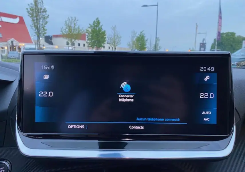 Écran tactile central du Peugeot 2008 blanc 2020 affichant la connexion Bluetooth et la température intérieure à 22°C.