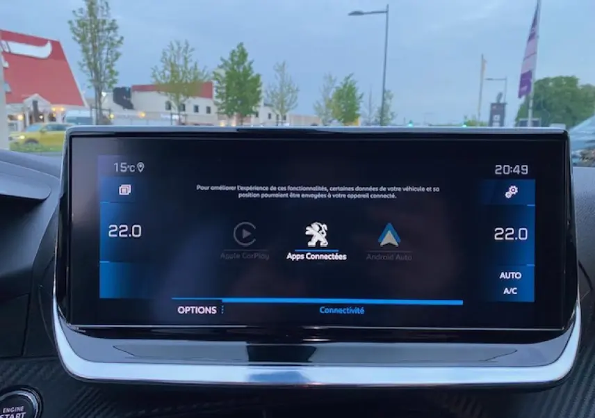 Écran tactile central du tableau de bord du Peugeot 2008 blanc, affichant la connectivité Apple CarPlay et Android Auto.