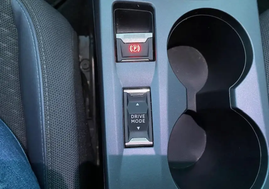 Gros plan sur la console centrale du Peugeot 2008 blanc, montrant le bouton Drive Mode et frein à main électronique.