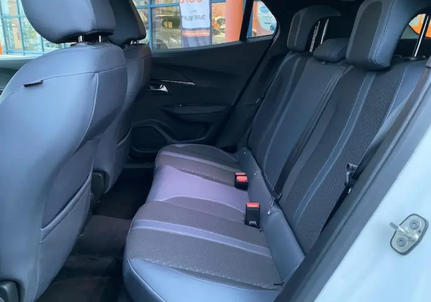 Vue intérieure côté droit sur la banquette arrière noire et grise du Peugeot 2008 blanc de 2020 avec appuie-têtes.