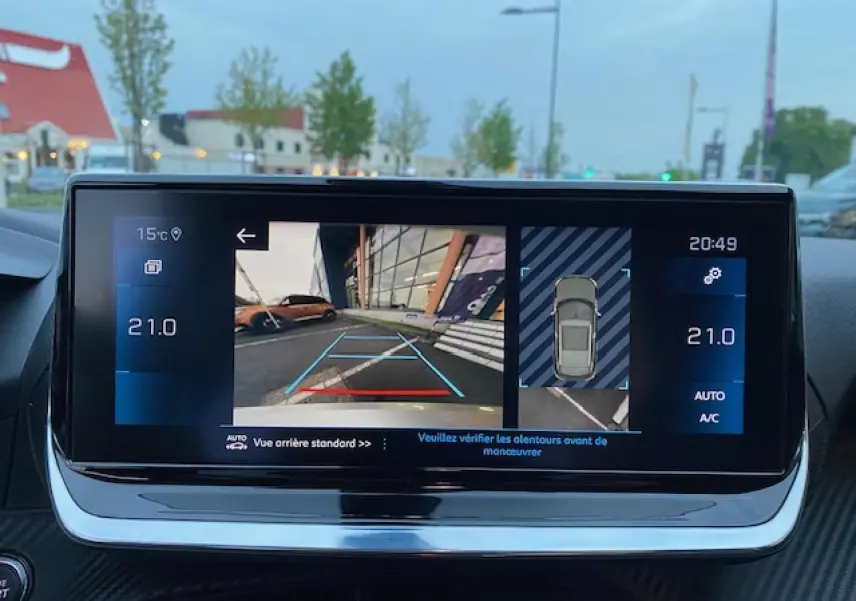 Écran tactile 7 pouces du Peugeot 2008 blanc montrant la caméra de recul et l'aide au stationnement.
