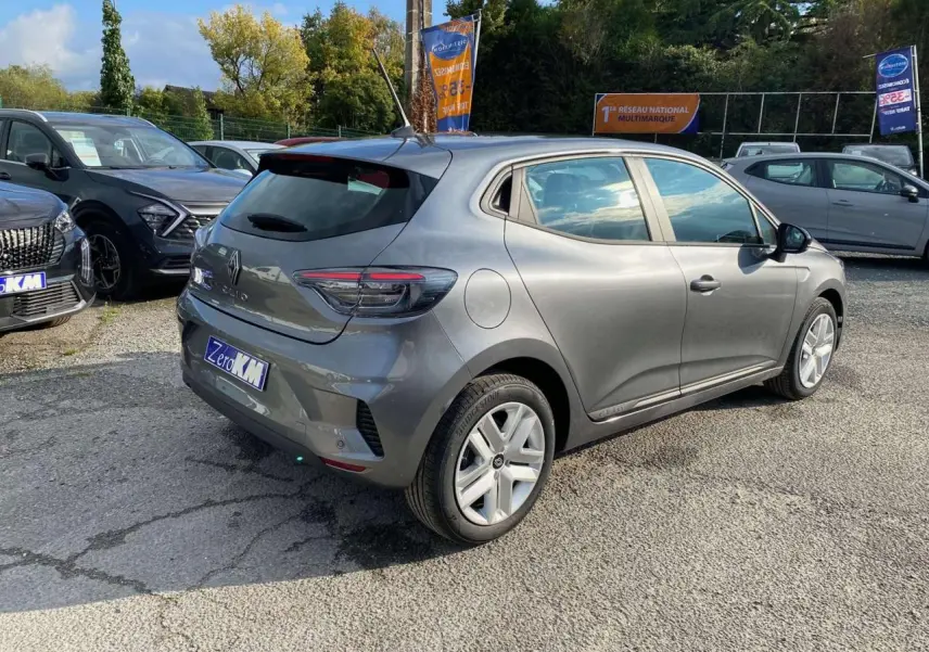 Renault Clio 2025 gris schiste vue 3/4 arrière droit sur parking avec antenne et jantes aluminium.