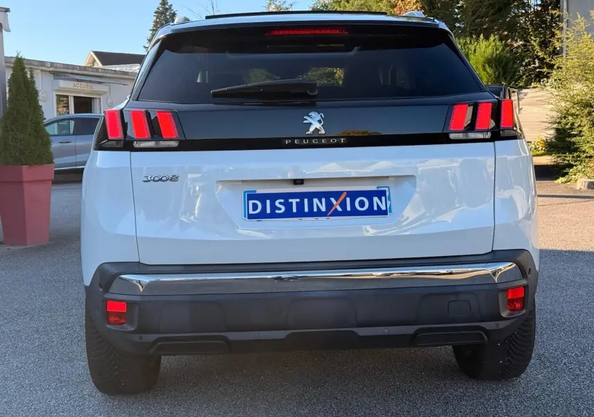 Vue arrière d'un Peugeot 3008 blanc nacré avec feux arrière à trois griffes rouges et plaque Distinxion.