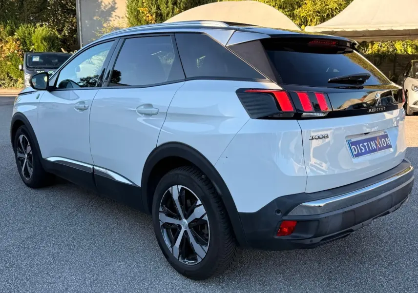 Peugeot 3008 blanc nacré vue 3/4 arrière droit, avec feux arrière à griffes et jantes alliage noires.