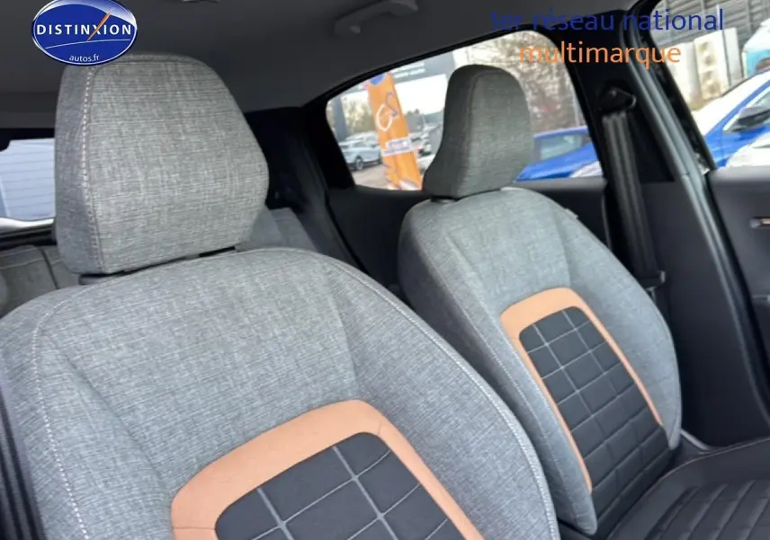 Vue intérieure rapprochée des sièges avant gris avec inserts noirs et marron dans une Citroën C3 Aircross 2025 noire.