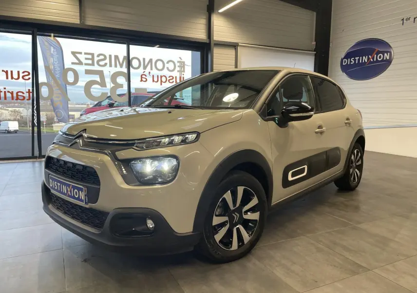 Citroën C3 beige clair vue 3/4 avant droit en showroom, avec Airbump noir et jantes alliage diamantées.
