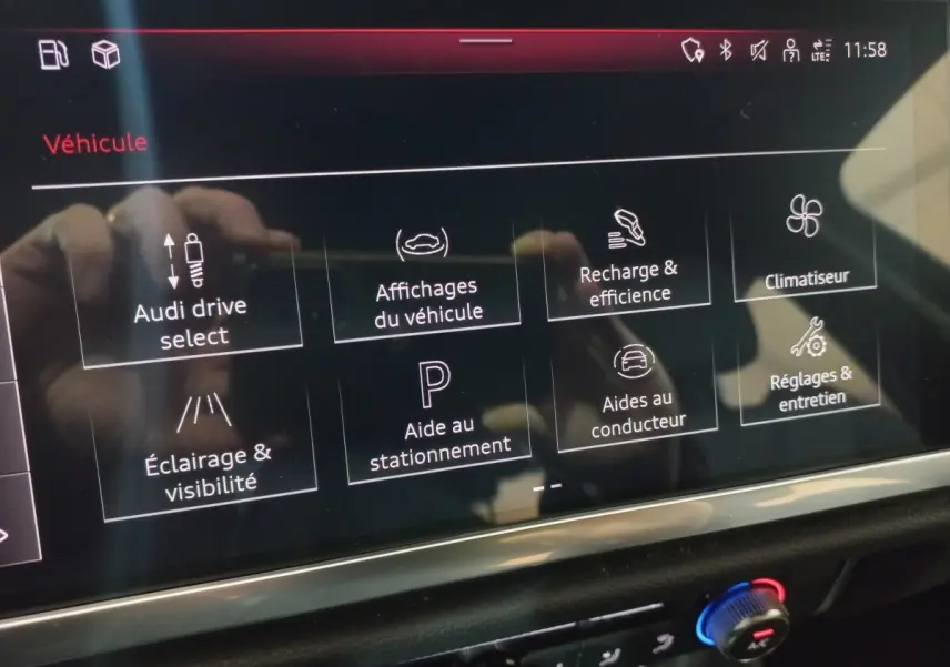 Écran tactile intérieur de l’Audi Q3 blanc 2021 affichant les options de conduite et d’aide au stationnement.