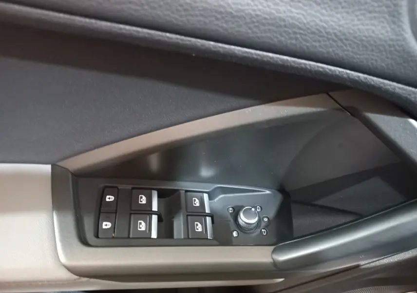 Gros plan sur les commandes de lève-vitres et réglage des rétroviseurs côté conducteur d'un Audi Q3 blanc 2021.
