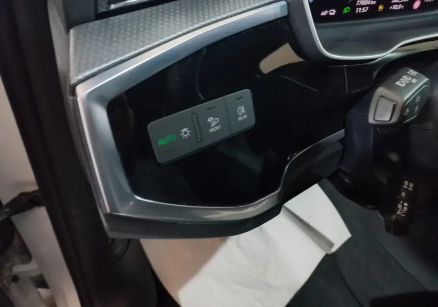 Vue intérieure côté gauche du tableau de bord noir brillant avec commandes d’éclairage de l’Audi Q3 blanc 2021 hybride rechargeable.