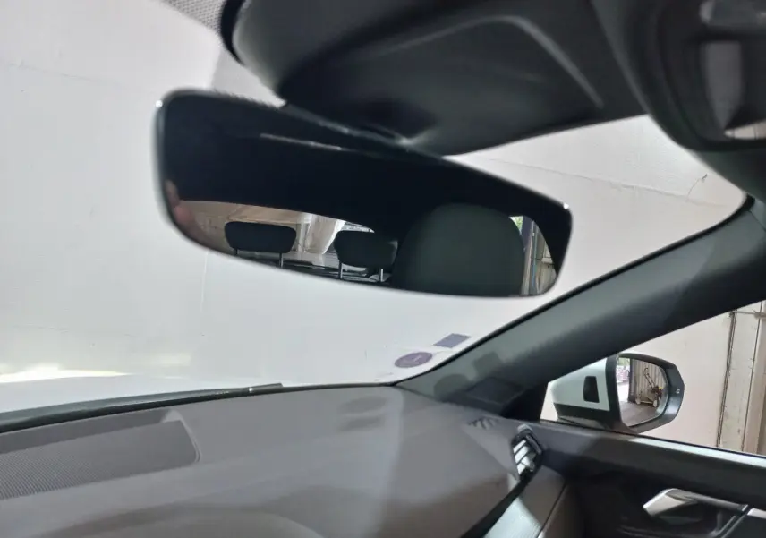 Vue intérieure de l'Audi Q3 45 TFSI e 2021, côté droit, montrant le rétroviseur intérieur et extérieur avec tableau de bord gris.