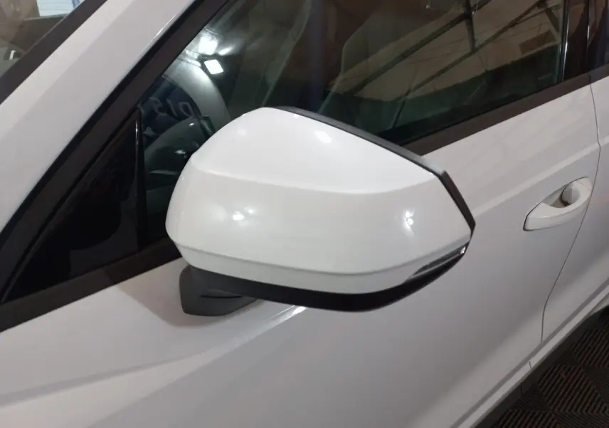 Rétroviseur droit blanc de l'Audi Q3 45 TFSI e S line 2021, avec porte et poignée visibles en arrière-plan.