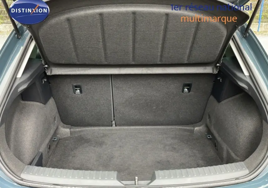 Coffre ouvert vu de l'arrière d'une SEAT LEON 2.0 TDI gris magnétique, montrant un espace de chargement propre et spacieux.