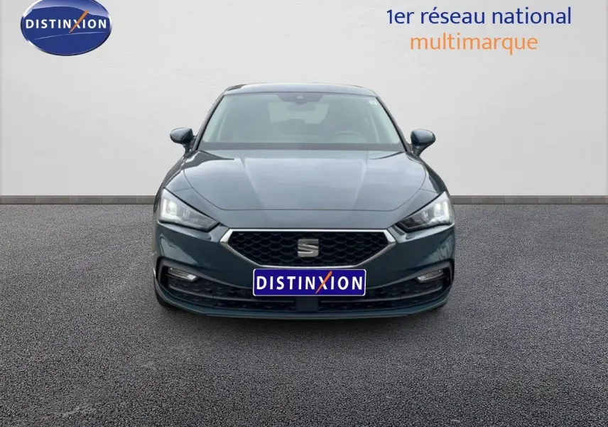Vue frontale d'une SEAT LEON 2.0 TDI gris magnétique métal avec calandre hexagonale et phares LED allumés.