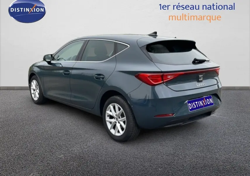 Vue 3/4 arrière droite d'une SEAT Leon 2025 gris magnétique métallisé avec jantes alliage et feux LED distinctifs.