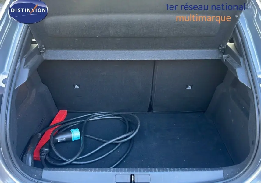 Coffre ouvert d'une Peugeot 208 électrique gris Artense de 2020 avec câble de recharge visible à l'intérieur.
