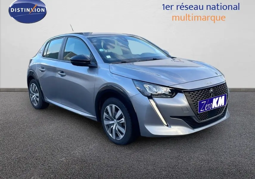 Peugeot 208 électrique gris Artense vue 3/4 avant gauche avec calandre distinctive et feux LED diurnes en forme de griffes.