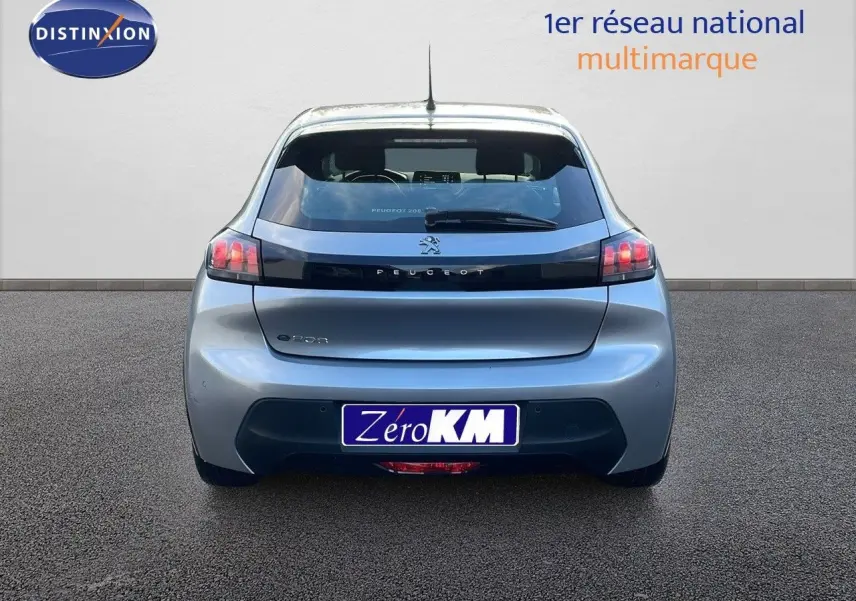 Vue arrière d'une Peugeot 208 électrique gris Artense avec feux arrière distinctifs et logo Peugeot visible.