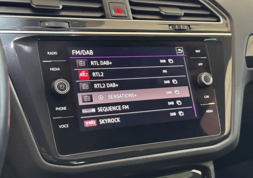 Écran tactile central du tableau de bord du Volkswagen Tiguan 2021 affichant les stations radio FM/DAB.