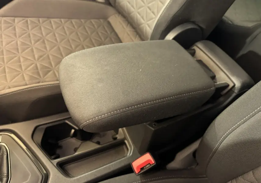 Gros plan sur l'accoudoir central et les sièges avant en tissu gris du Volkswagen Tiguan bleu, version 2021.