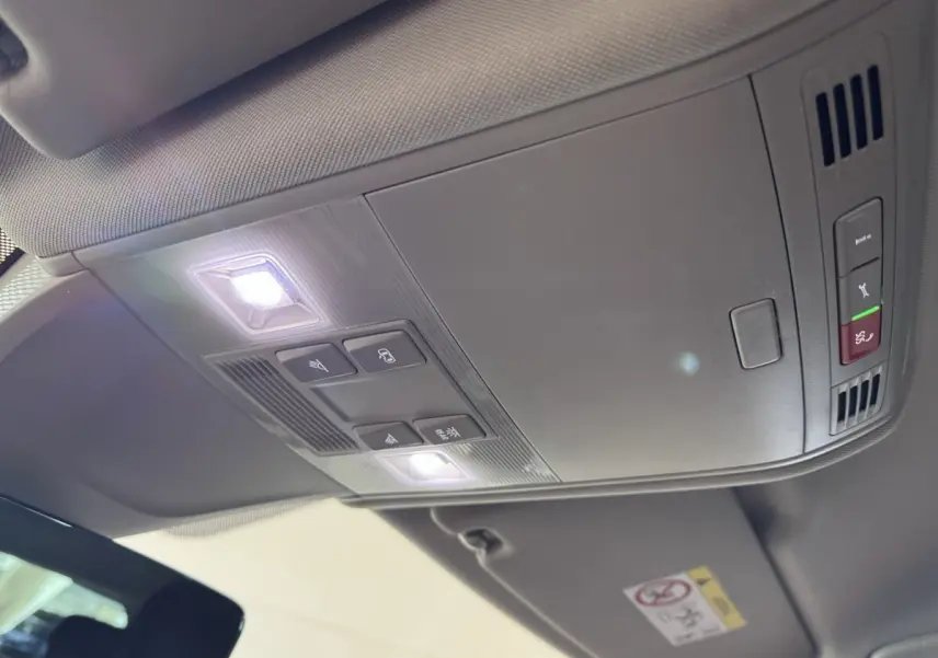 Vue intérieure du plafond avant du Volkswagen Tiguan bleu 2021, avec éclairage et commandes intégrées.