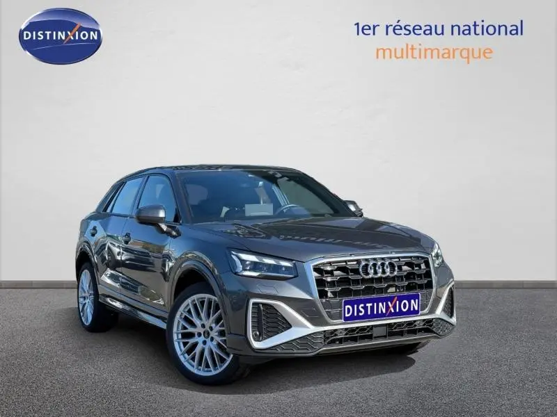 Audi Q2 35 TDI S line gris Daytona nacré en 3/4 avant, mettant en valeur sa calandre distinctive et ses jantes alliage.