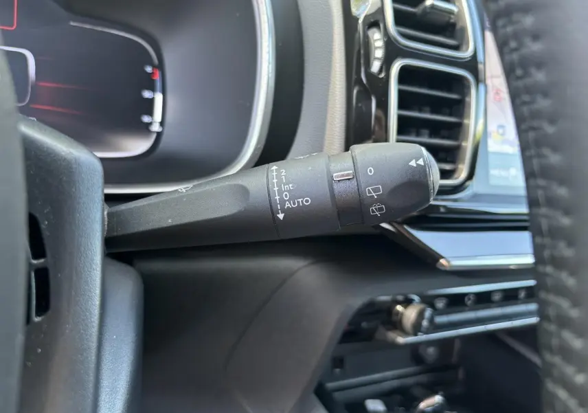 Gros plan sur la commande d'essuie-glace à gauche du volant dans l'habitacle noir du Citroën C5 Aircross Shine 2019.