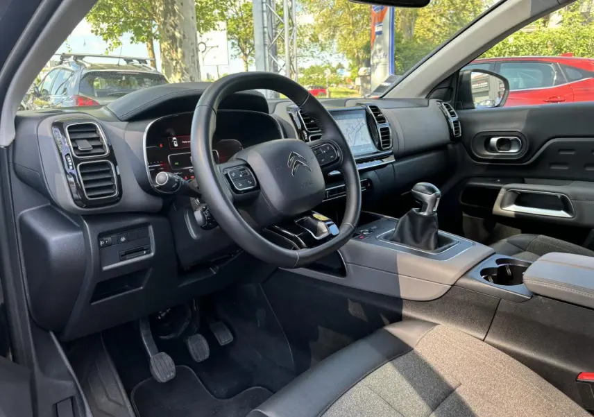 Intérieur du Citroën C5 Aircross 2019 vu côté conducteur, volant multifonction et levier de vitesses manuel visibles.