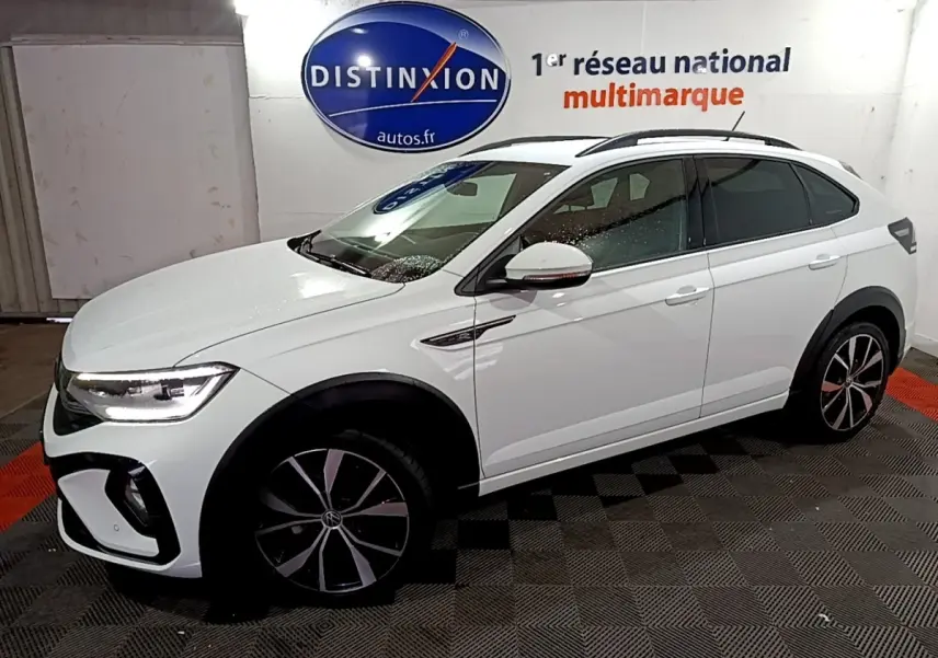 Vue 3/4 avant droit d'un Volkswagen Taigo blanc 2022 avec jantes alliage noires et toit ouvrant panoramique.