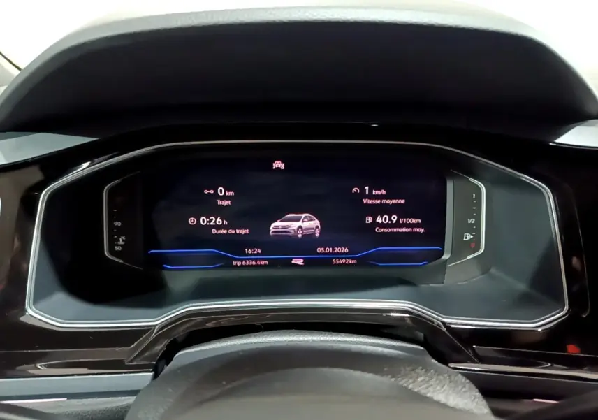 Tableau de bord numérique du Volkswagen Taigo blanc 2022, affichage multifonctions avec informations de trajet et consommation.