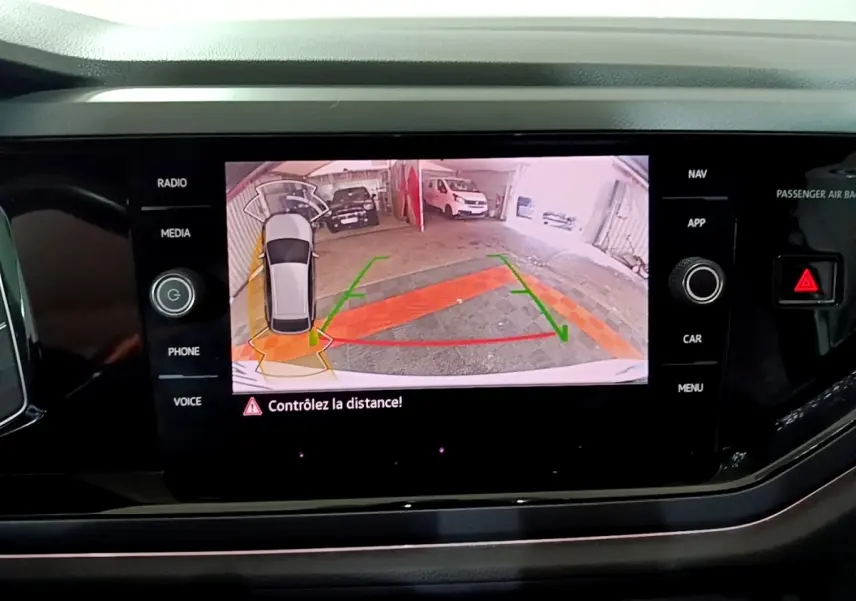 Affichage de la caméra de recul du Volkswagen Taigo blanc, vue arrière avec guidage de stationnement sur écran central.