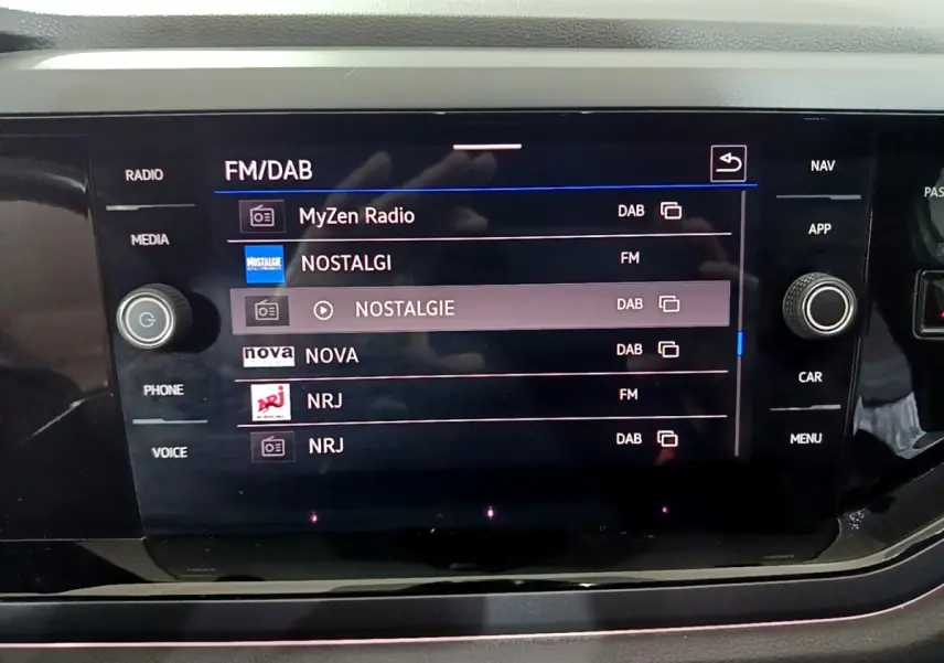Écran tactile central du Volkswagen Taigo 2022 affichant les stations radio FM/DAB avec commandes autour.