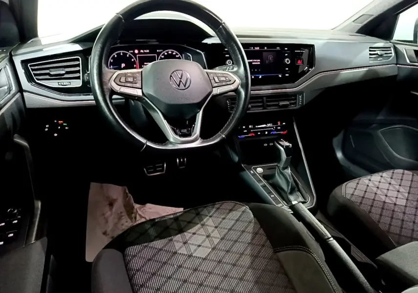 Vue intérieure avant du Volkswagen Taigo 1.0 TSI 110 DSG R-Line, volant cuir alu multifonctions et tableau de bord digital.