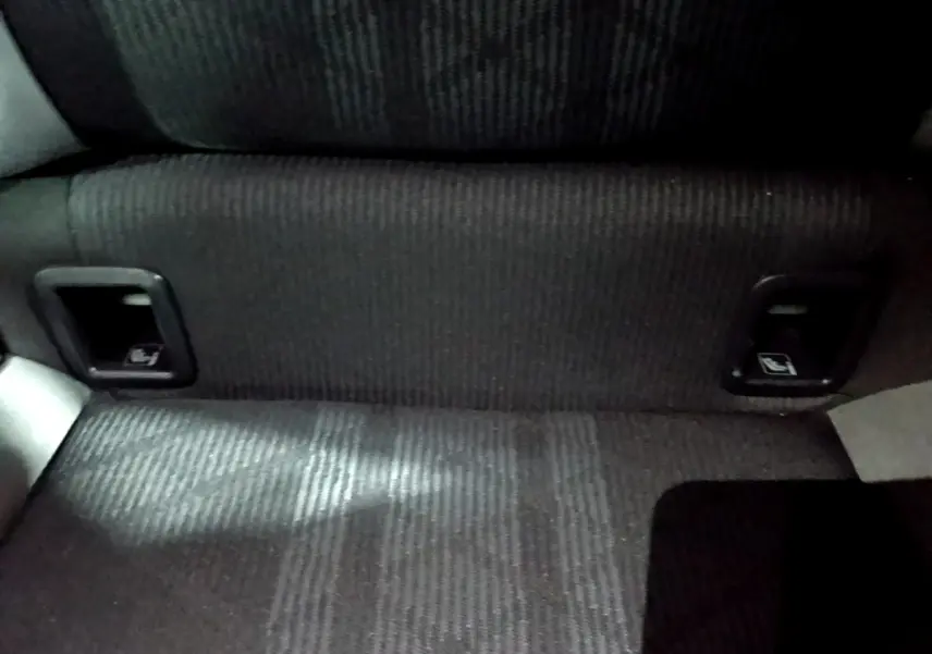 Détail de la banquette arrière noire du Volkswagen Taigo 1.0 TSI 110 DSG R-Line, avec commandes de rabattement intégrées.