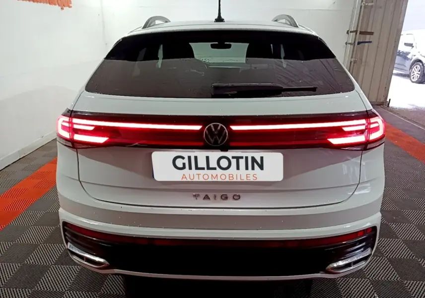 Vue arrière d’un Volkswagen Taigo blanc 2022 avec feux LED allumés et logo VW centré sur le hayon.