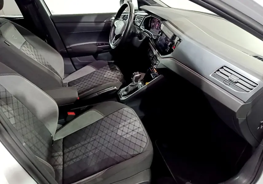Intérieur avant droit du Volkswagen Taigo 1.0 TSI 110 DSG R-Line avec sièges tissu gris et tableau de bord moderne.