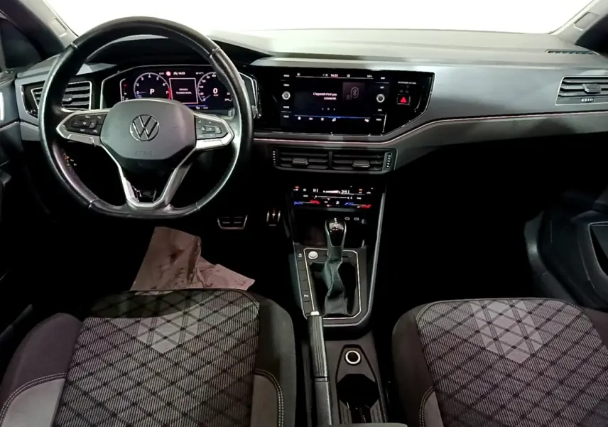 Vue intérieure frontale du Volkswagen Taigo 1.0 TSI 110 DSG R-Line avec volant cuir alu multifonctions et tableau de bord digital.