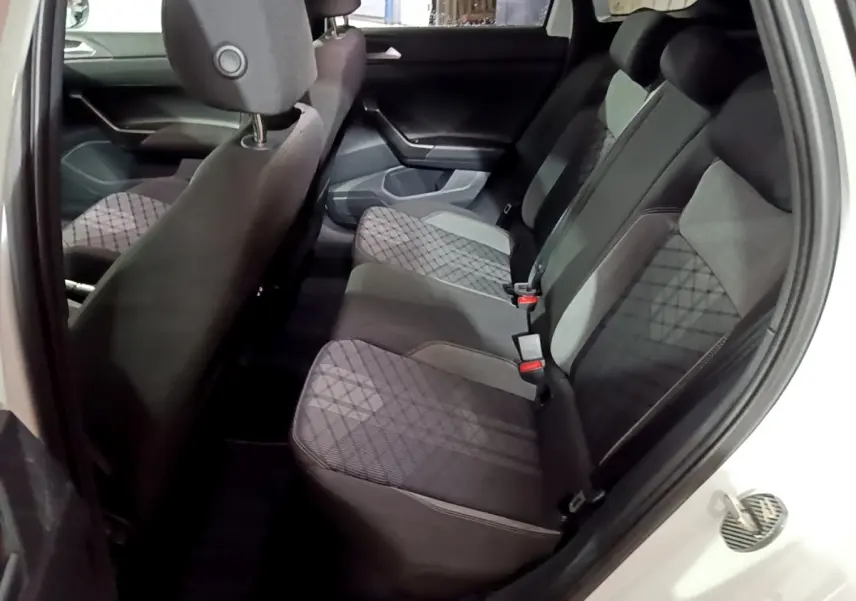 Vue intérieure arrière droite du Volkswagen Taigo blanc 2022, montrant la banquette tissu avec motifs géométriques.