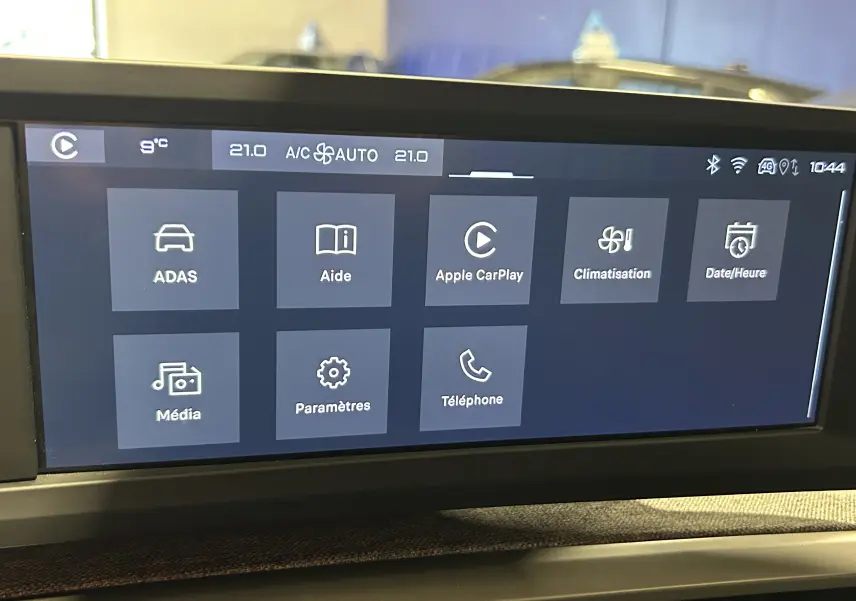 Écran tactile central du Peugeot 5008 III Hybrid 145 en mode menu avec options Apple CarPlay et climatisation visible.