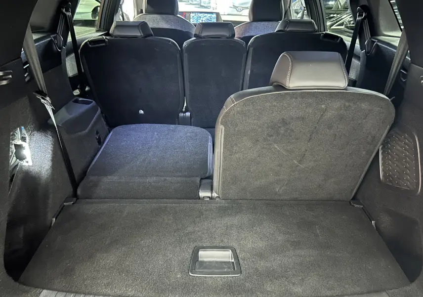 Vue intérieure du coffre du Peugeot 5008 gris Artense avec siège arrière droit relevé et gauche rabattu.