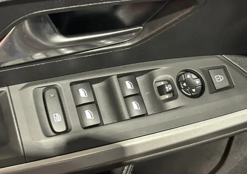 Gros plan sur les commandes de lève-vitres et rétroviseurs côté conducteur du Peugeot 5008 gris Artense.