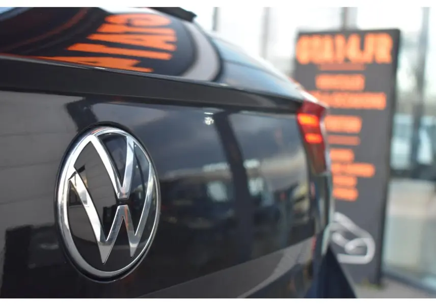 Gros plan sur l'arrière droit d'un Volkswagen T-Roc noir grenadilla avec logo VW et feu arrière LED rouge clair.