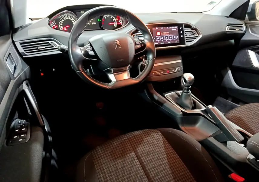 Intérieur de la Peugeot 308 gris clair, vue côté conducteur sur le volant cuir, tableau de bord et écran tactile 9,7 pouces.