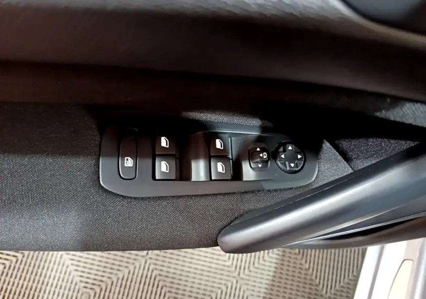 Panneau de commandes des vitres et rétroviseurs côté conducteur de la Peugeot 308 gris clair, intérieur tissu noir.