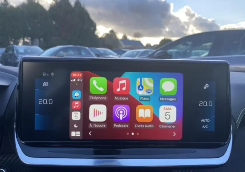 Écran tactile 10 pouces du Peugeot 2008 noir 2021 affichant interface Apple CarPlay en extérieur.