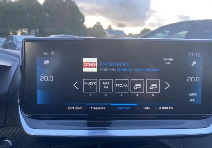 Écran tactile 10 pouces du Peugeot 2008 noir 2021 affichant la radio FM Skyrock et la température intérieure à 20°C