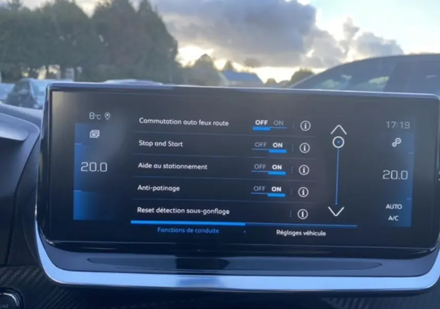 Écran tactile du tableau de bord du Peugeot 2008 noir affichant les réglages d’aides à la conduite par temps clair.