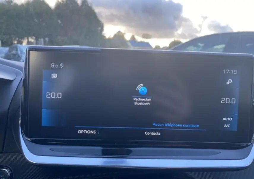 Écran tactile central du Peugeot 2008 noir 2021 affichant la recherche Bluetooth, avec tableau de bord en arrière-plan.