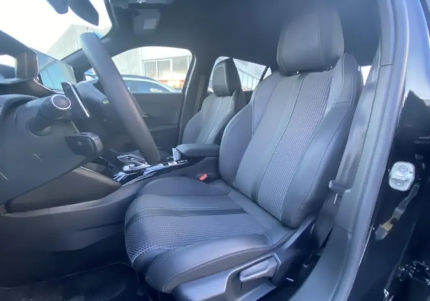 Intérieur avant droit du Peugeot 2008 noir 2021, siège en cuir et tissu avec console centrale visible.